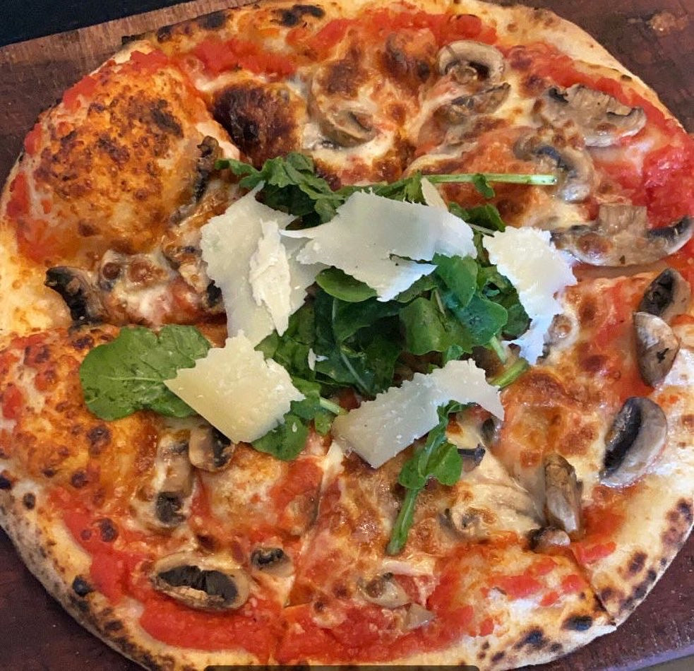 Truffle, Arugula, & Mushroom Pizza topped with Parmesan Shavings
