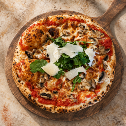 Truffle arugula mushroom sourdough pizza on a wooden pizza peel